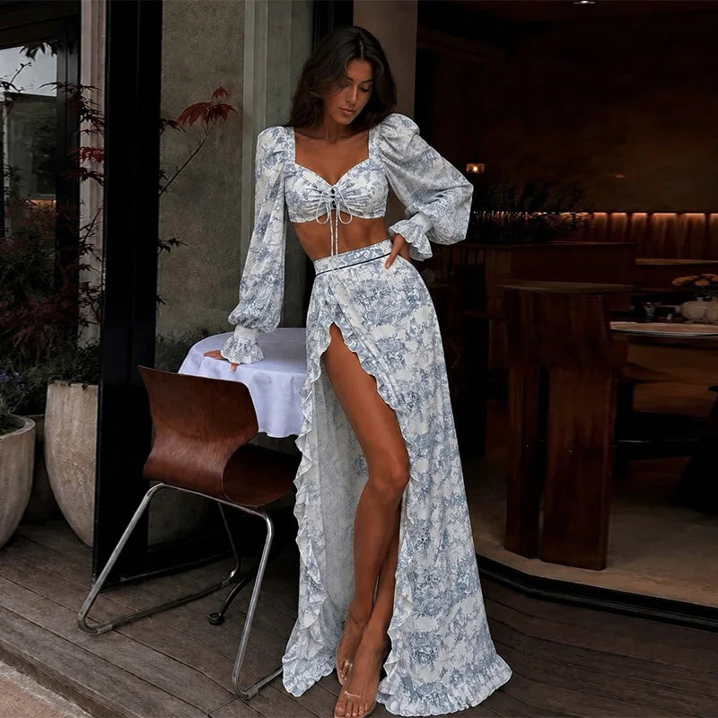 Completo da donna con top corto a stampa floreale, maniche lunghe, top con fiocco, gonna a balze con spacco alto, abiti estivi da spiaggia per le vacanze 2026.