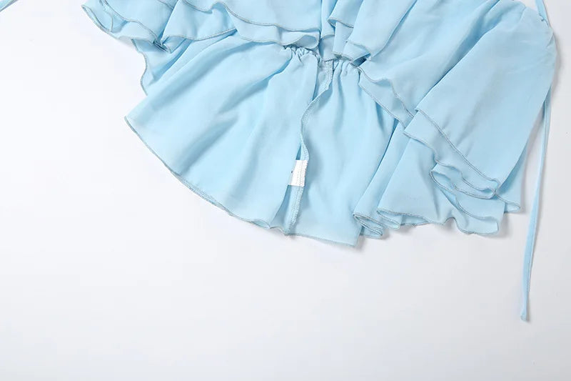 Completo coordinato due pezzi da donna sexy con scollo all'americana e volant, top corto senza schienale e minigonna pantaloncino, moda estate 2026 per vacanze