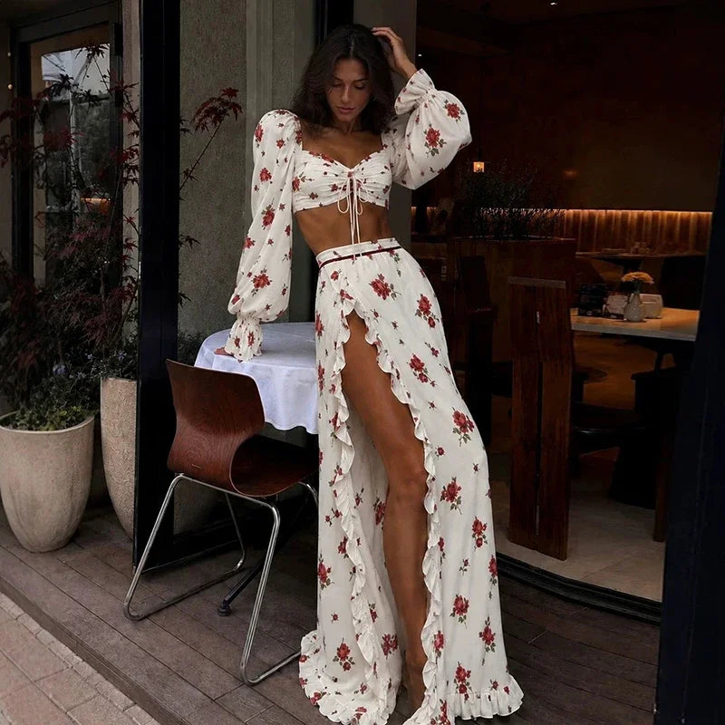 Completo da donna con top corto a stampa floreale, maniche lunghe, top con fiocco, gonna a balze con spacco alto, abiti estivi da spiaggia per le vacanze 2026.