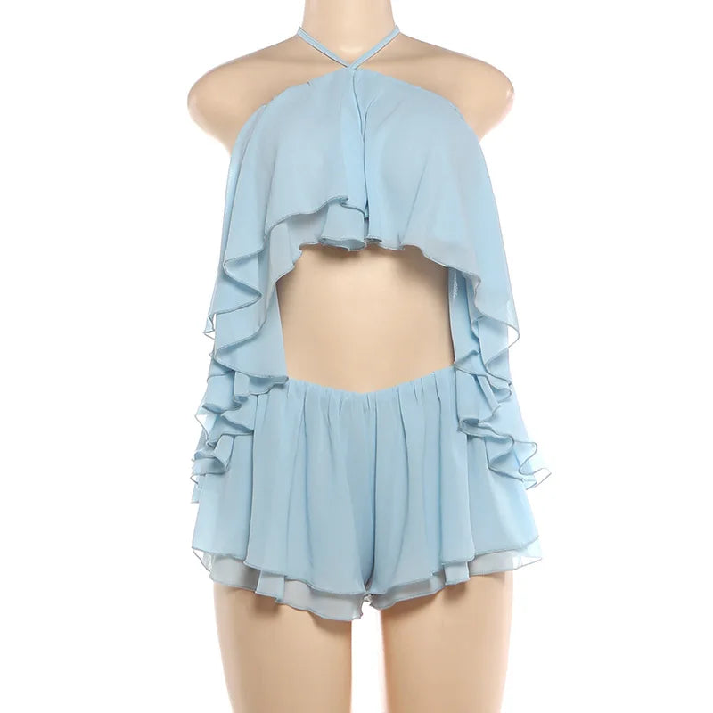 Completo coordinato due pezzi da donna sexy con scollo all'americana e volant, top corto senza schienale e minigonna pantaloncino, moda estate 2026 per vacanze
